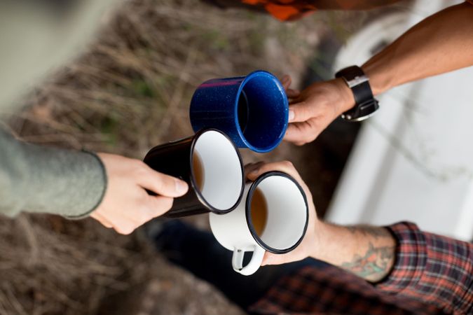 Three friends toasting with camper mugs