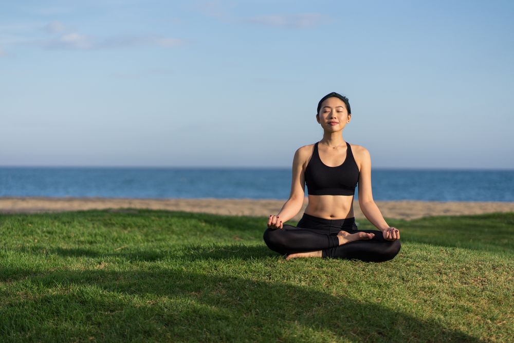Woman meditating on the beach