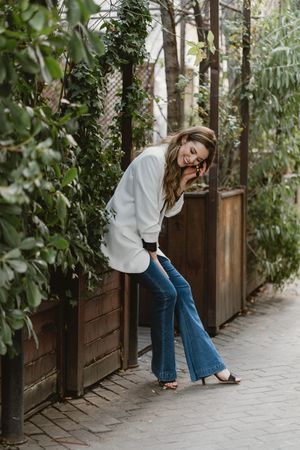 Woman sitting on planter in garden