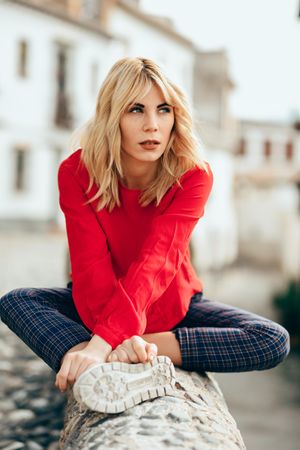 Woman sitting on rocky stoop in Spanish town