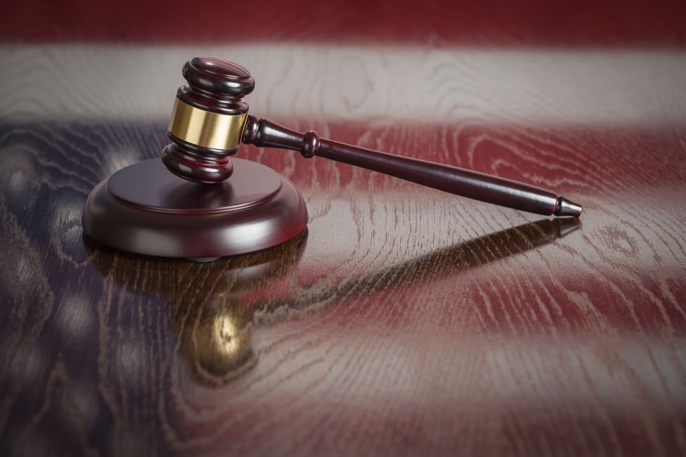 Wooden Gavel Resting on Flag Reflecting Table