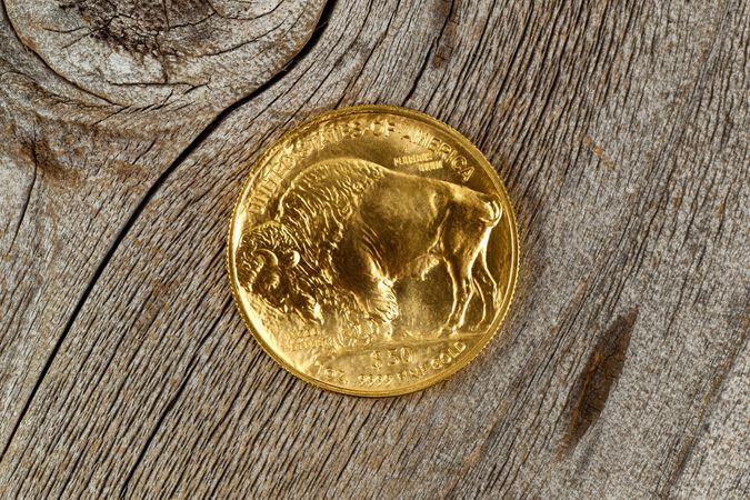 Fine gold Buffalo Coin on rustic wood