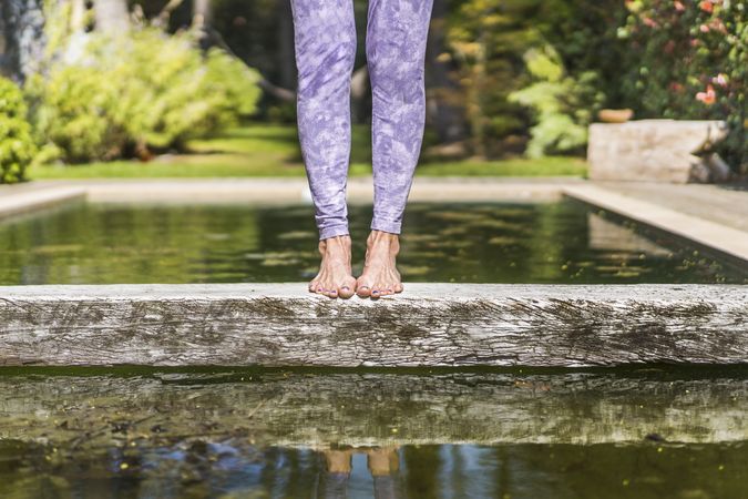 Woman's legs standing on a trunk over the water. Copy space