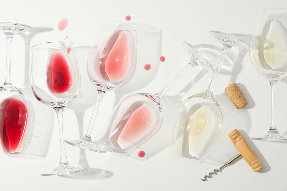Flat lay composition. Corkscrew, glasses with different wine on blank background