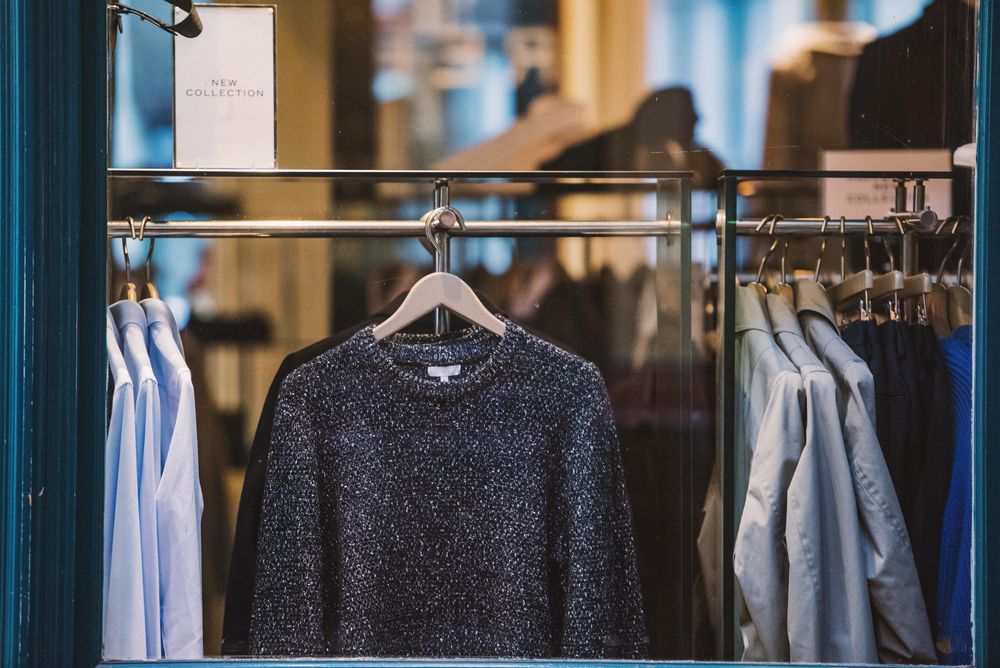 Exterior view of fashion store displaying sweaters and shirts