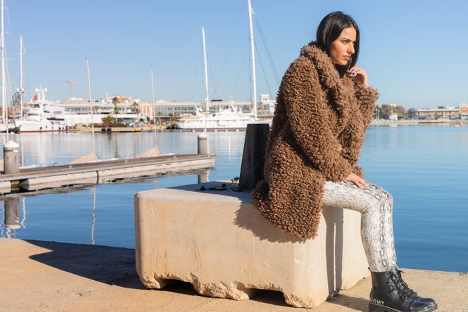 Stylish female sitting in harbor