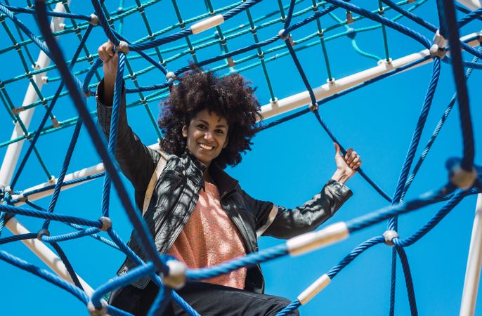 Woman with afro hair climbing by children's attractions.