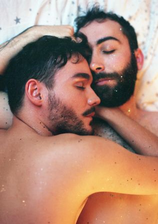 Two topless men cuddling