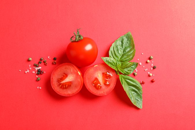 Flat lay composition with fresh cherry tomatoes, basil and pepper on color background, space for text. Ripe vegetables