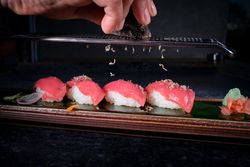 Crop chef decorating sushi with truffle