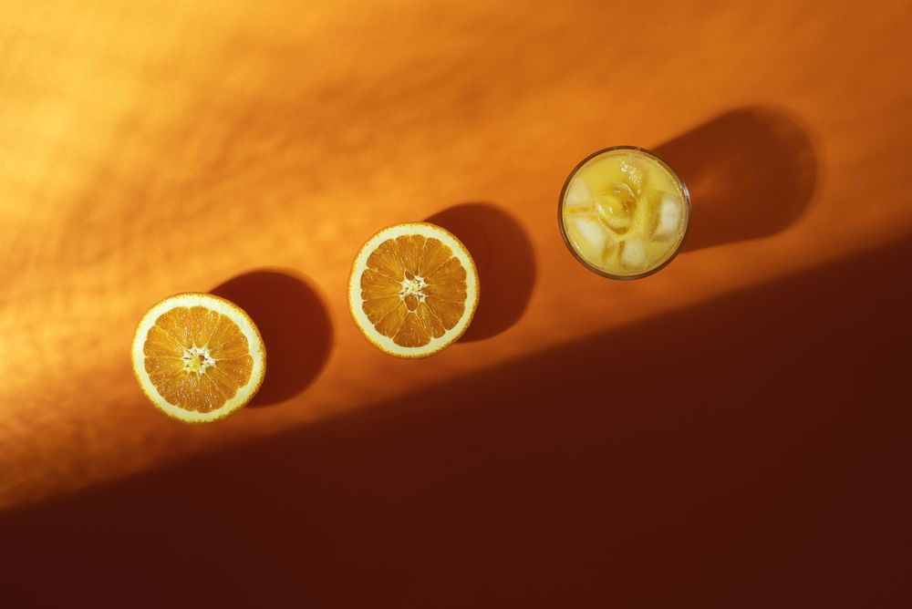 Fresh orange juice glass and orange fruit cut in half