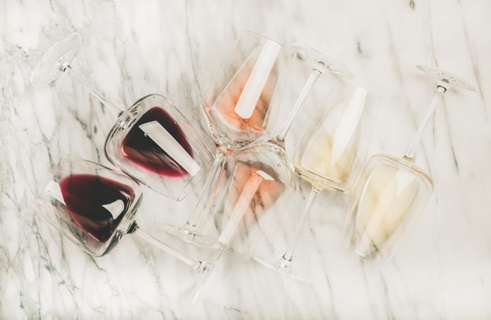 Glasses of wine laying on marble background