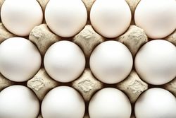 Chicken eggs in carton box as background, space for text