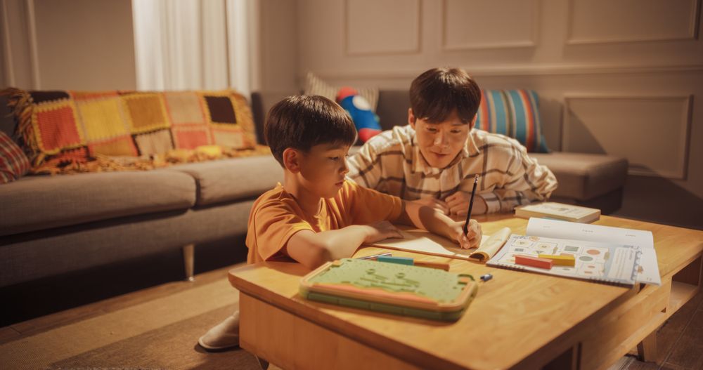 Focused Kid Learning, Studying Hard. Helpful High Achieving Korean Family. Evening Home