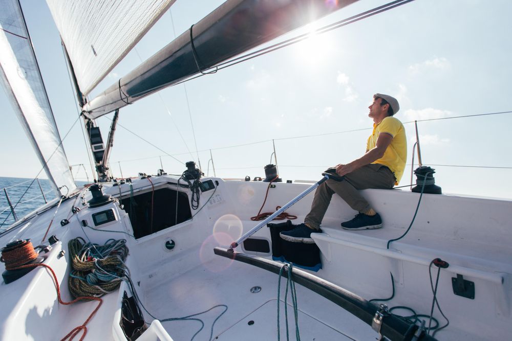 Sailor navigating boat on sunny day