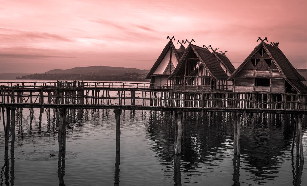 Thatched cottages suspended on stilts over lake