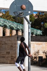 Anonymous Black man playing basketball on sports ground