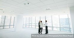 Estate agent with clients inside an empty office space 5r9vMd