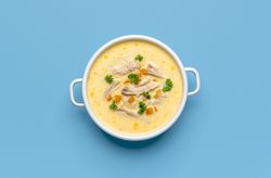 Greek chicken soup avgolemono, above view on a blue background