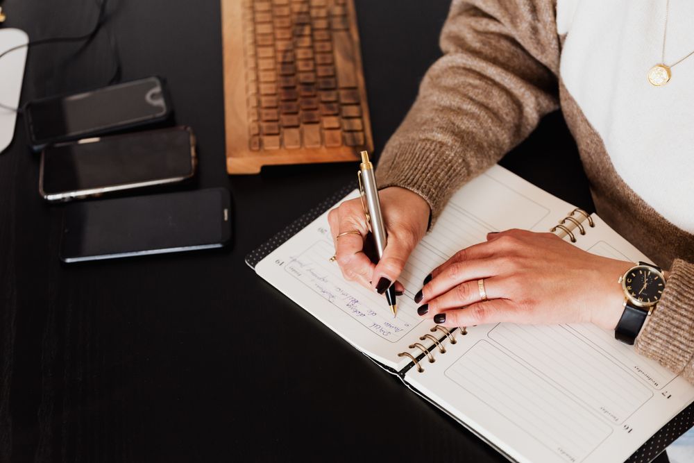 Woman writing a note sitting at the desk