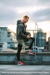 Fitness man standing on rooftop holding a medicine ball 4163pb
