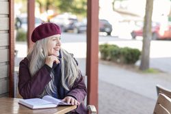 Smiling woman holding a pen and notebook