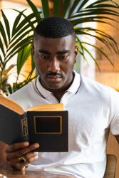 Serious male reading book in cafeteria