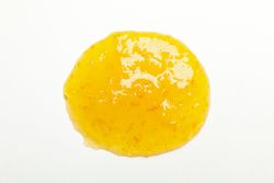 Apricot jam isolated on plain background, close up