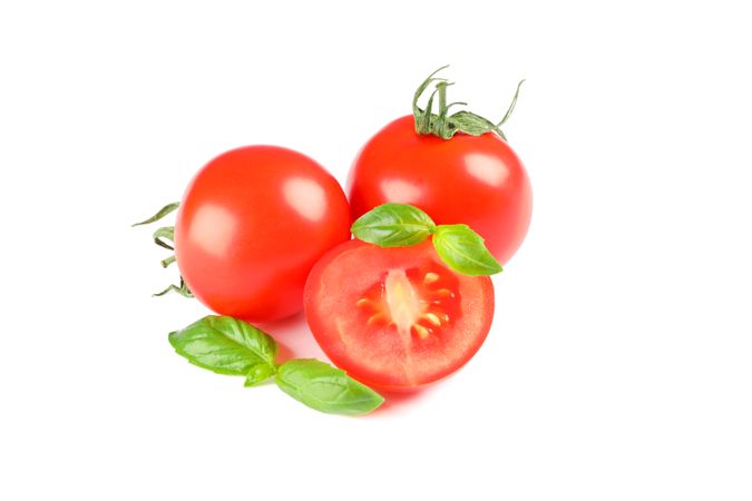 Fresh cherry tomatoes with basil isolated on light background. Ripe vegetables