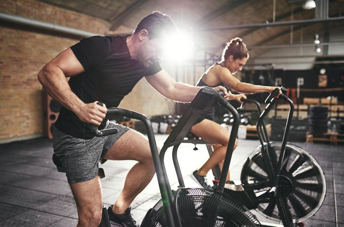 Fit couple taking workout class together at indoor gym
