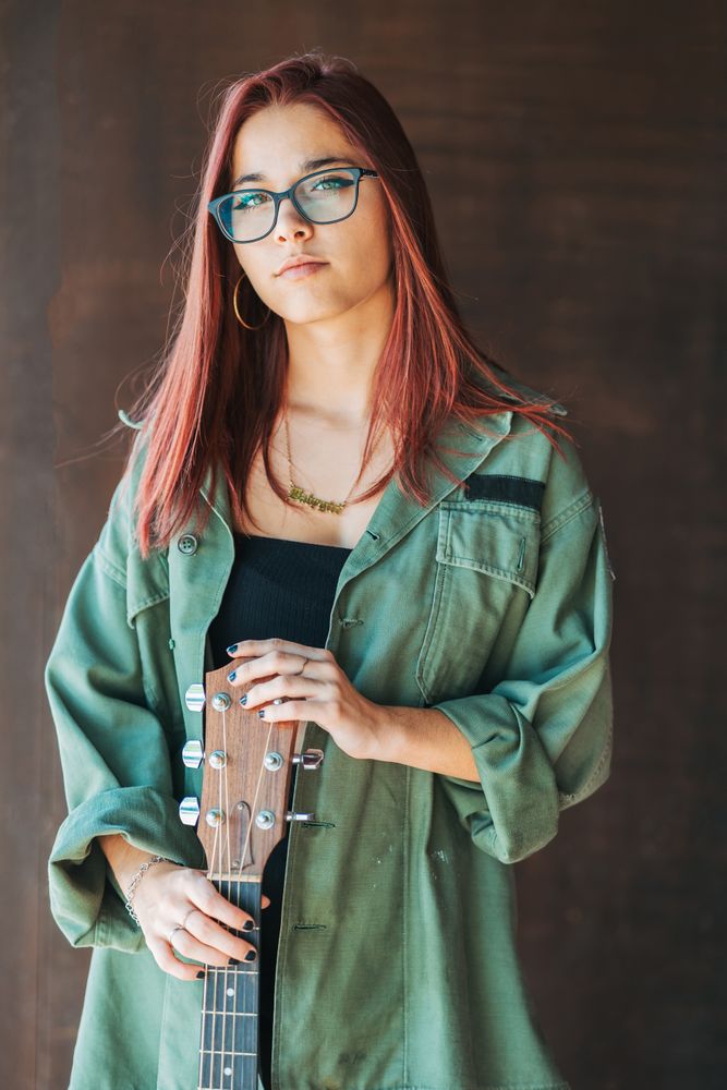Woman in glasses leaning on wall
