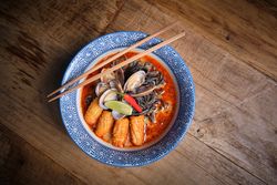 Typical hot ramen dish with fish broth in a bowl with noodles, squid, chilli, clams.