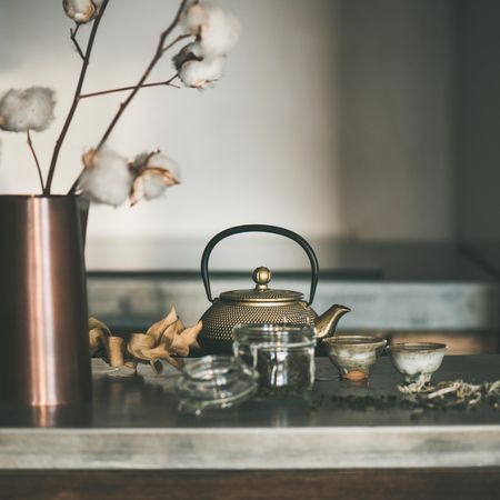 Traditional Japanese tea set, on kitchen counter, with dried cotton, square crop