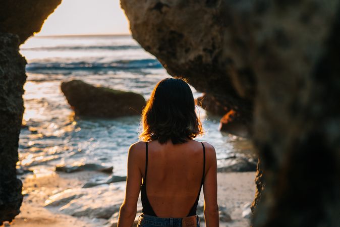 Back of woman seen through beach cave