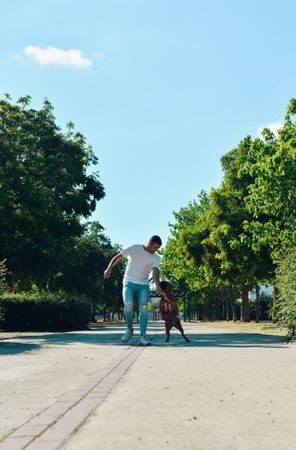 Man running and playing with his dog.