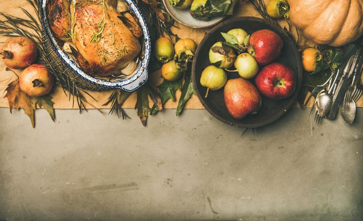 Roast turkey in roasting pan, on table with leaves and fruit, horizontal composition, copy space