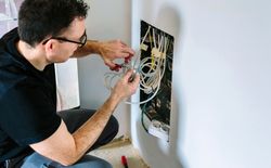 Technician cutting cable to install telecommunication box