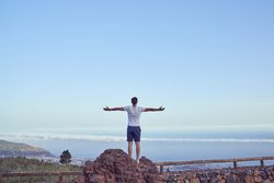 Unrecognizable man standing above town on fence