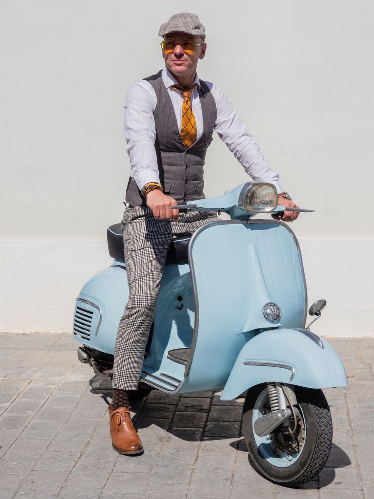 Trendy man sitting on vintage scooter