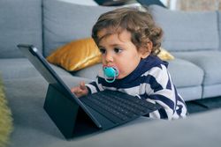 Little boy with tablet on sofa at home