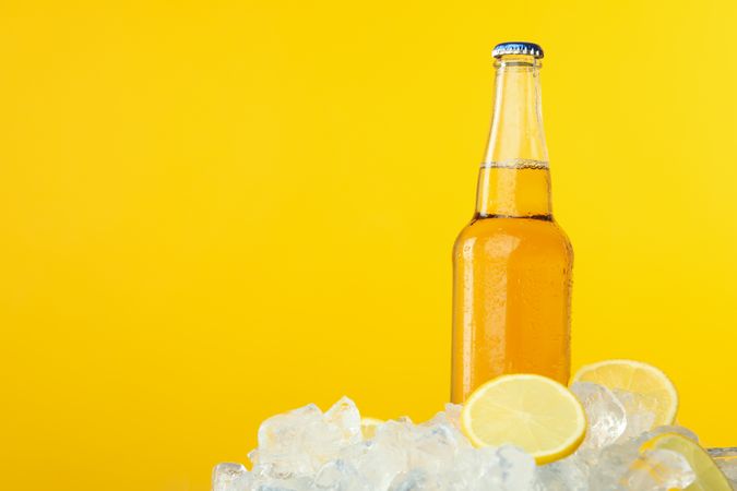 Bottle full of orange liquid on yellow background