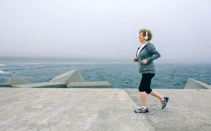 Older woman with headphones running