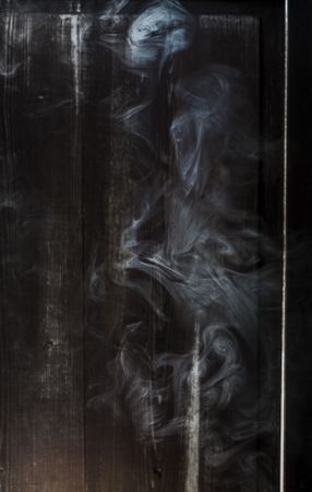 Smoke swirling in a dark wooden room