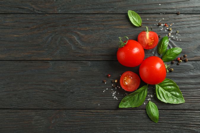 Flat lay composition with fresh tomatoes, salt, pepper and basil on wooden background, space for text. Ripe vegetables