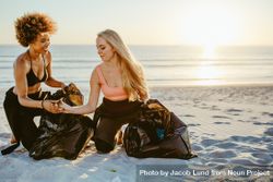 Women surfers cleaning the beach and collecting the litter in garbage bag 5r3874