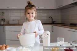 Young girl holding light bowl in the kitchen 5kwJW5