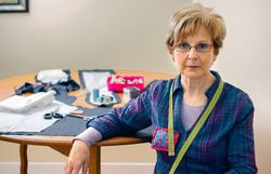 Mature dressmaker posing with sewing materials