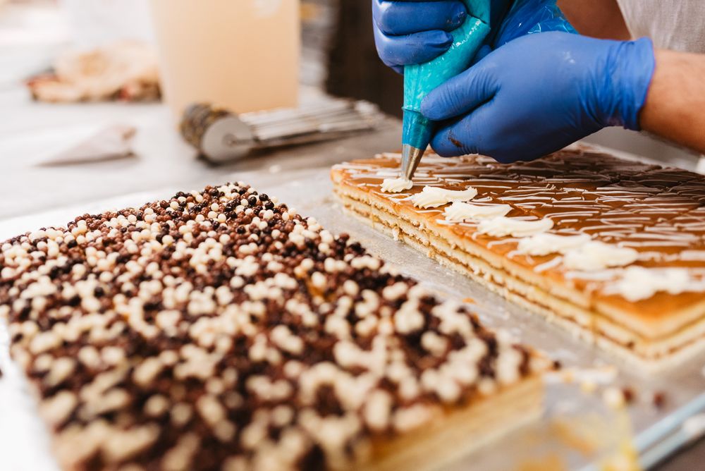 Crop baker squeezing dough on tray