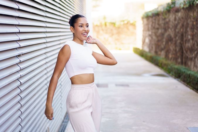 Chic Young Woman Posing Confidently in a Vibrant Urban Setting with Aesthetic Background