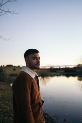 Young man watching the sunset at a lake in the countryside